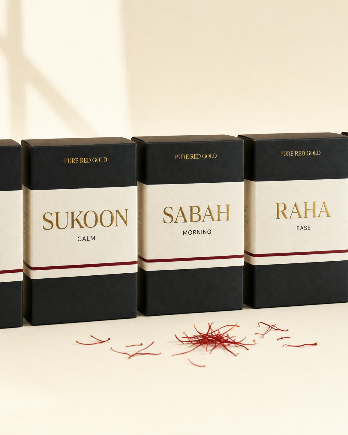 The five herbal tea boxes in a row — black boxes with cream bands and gold serif names on warm ivory